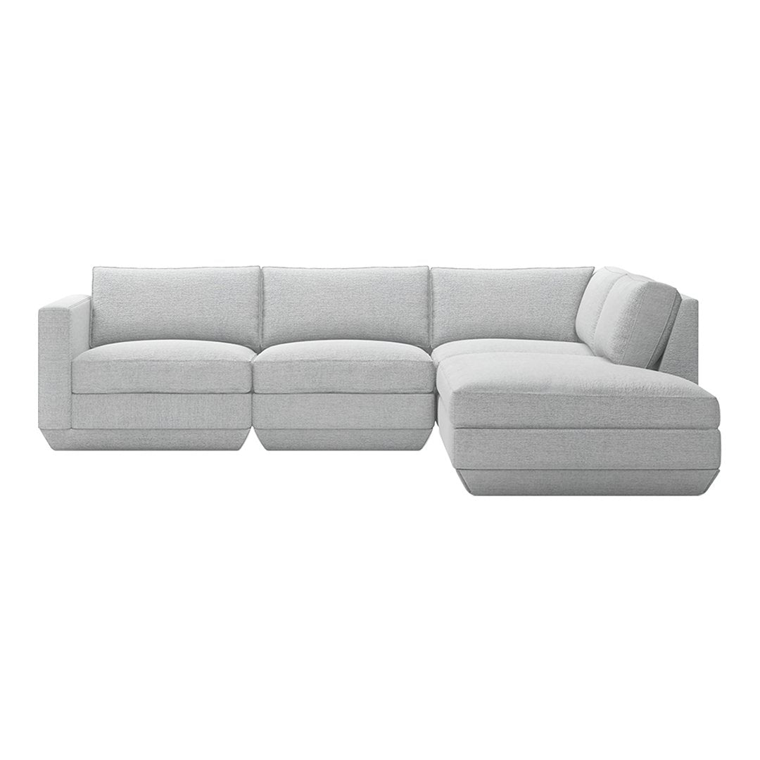 Light gray sectional sofa with soft fabric and minimalistic design, featuring subtle stitching details.