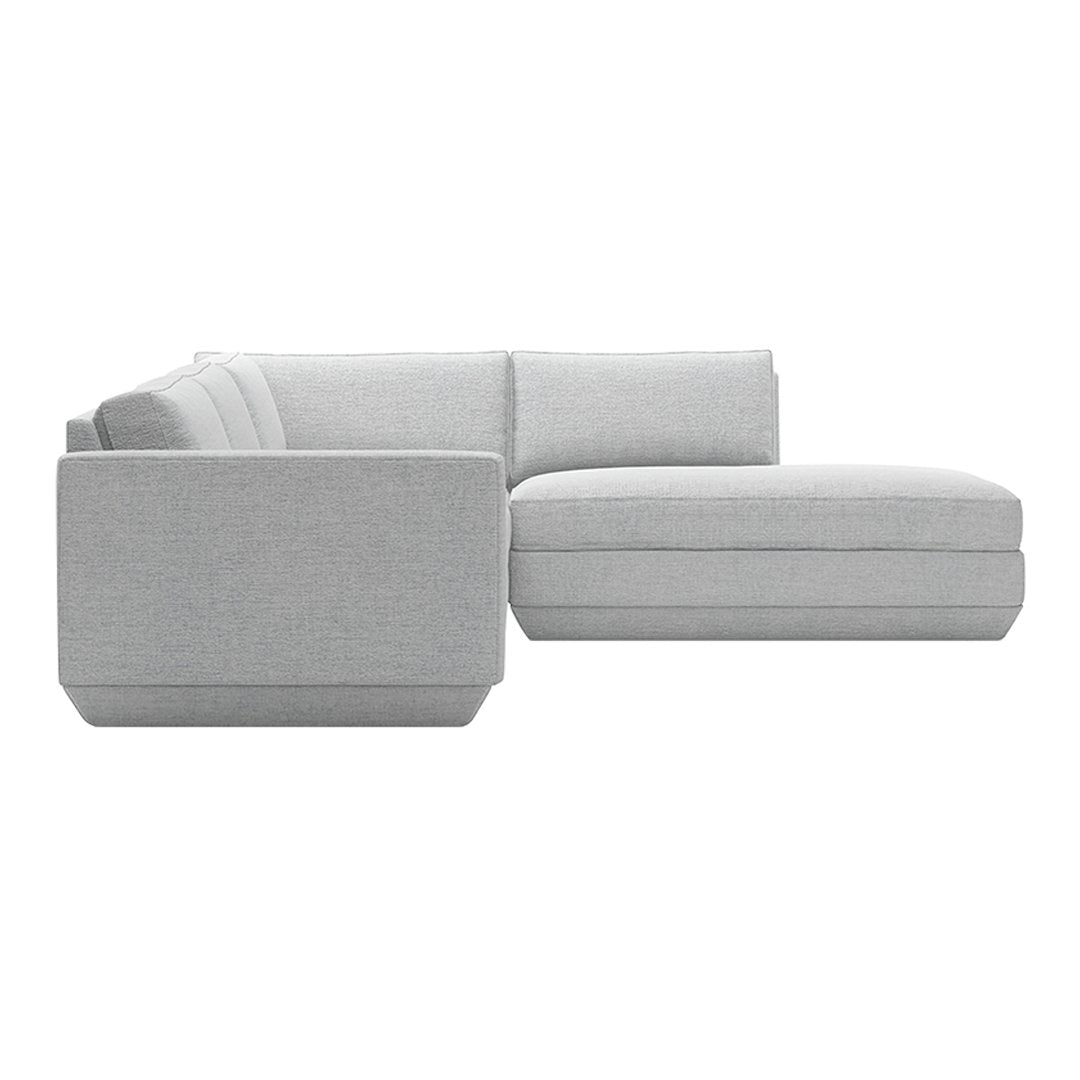 Gray sectional sofa with smooth fabric and clean lines, featuring a minimalist design and modern aesthetic.