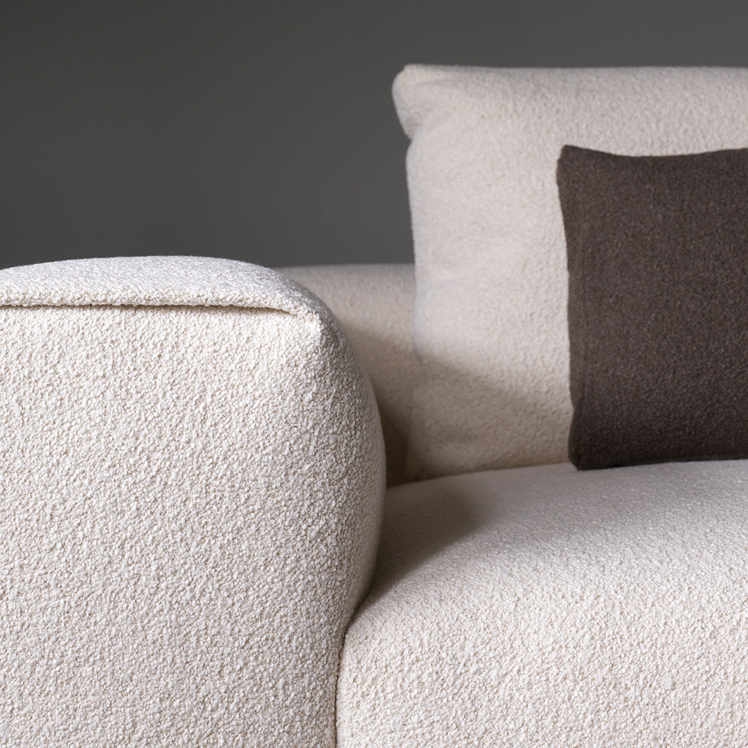 Textured white upholstery sofa with a dark brown accent pillow, featuring a clean and modern design.