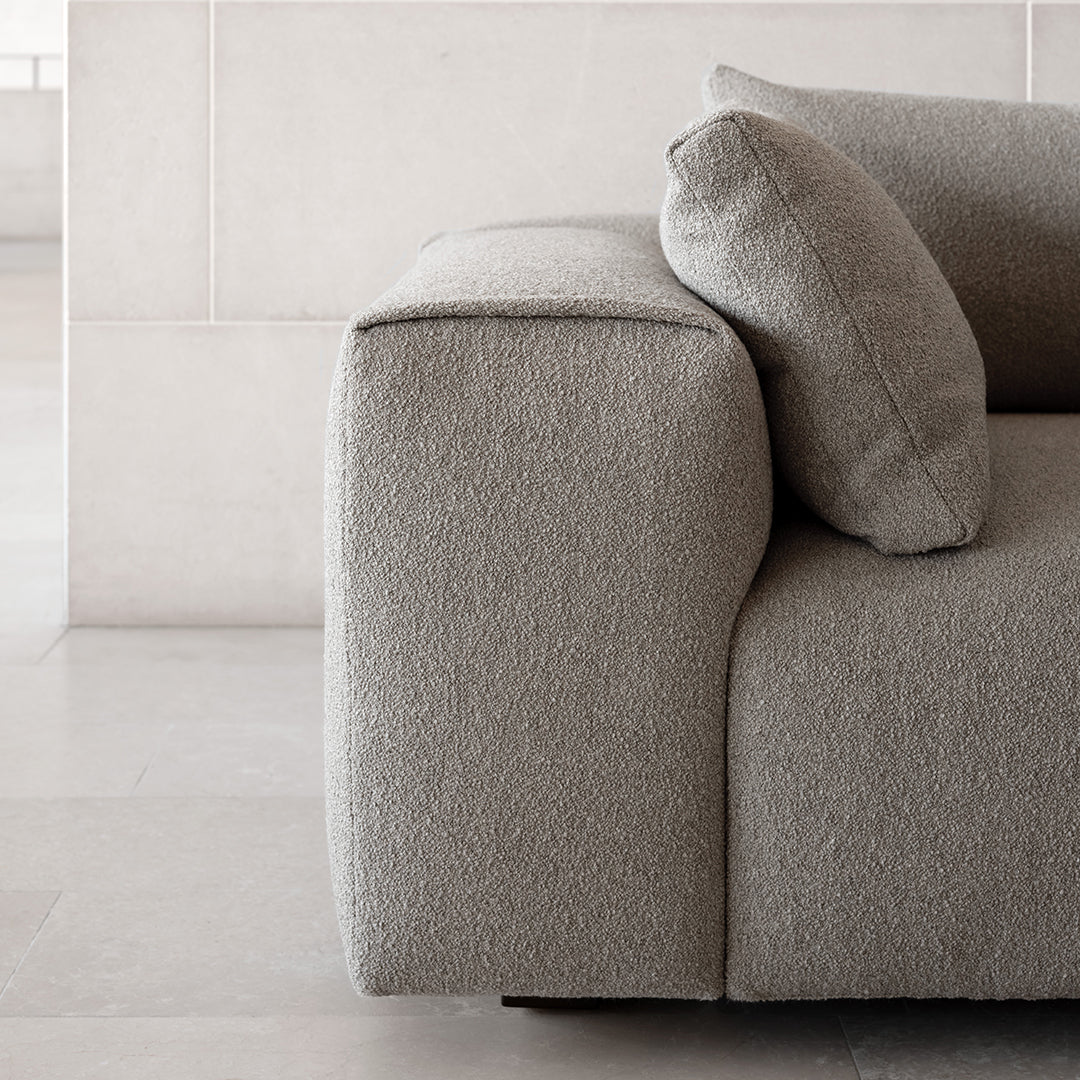 Soft gray textured fabric sofa with a clean, modern design and matching throw pillow, ideal for contemporary decor.