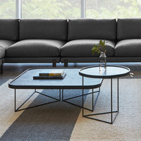 Modern black metal coffee tables with geometric patterns, featuring a sleek gray tabletop and minimalist design.