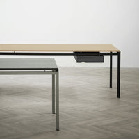 Minimalist tables featuring a light wooden top and sleek gray metal legs, set against a neutral background.