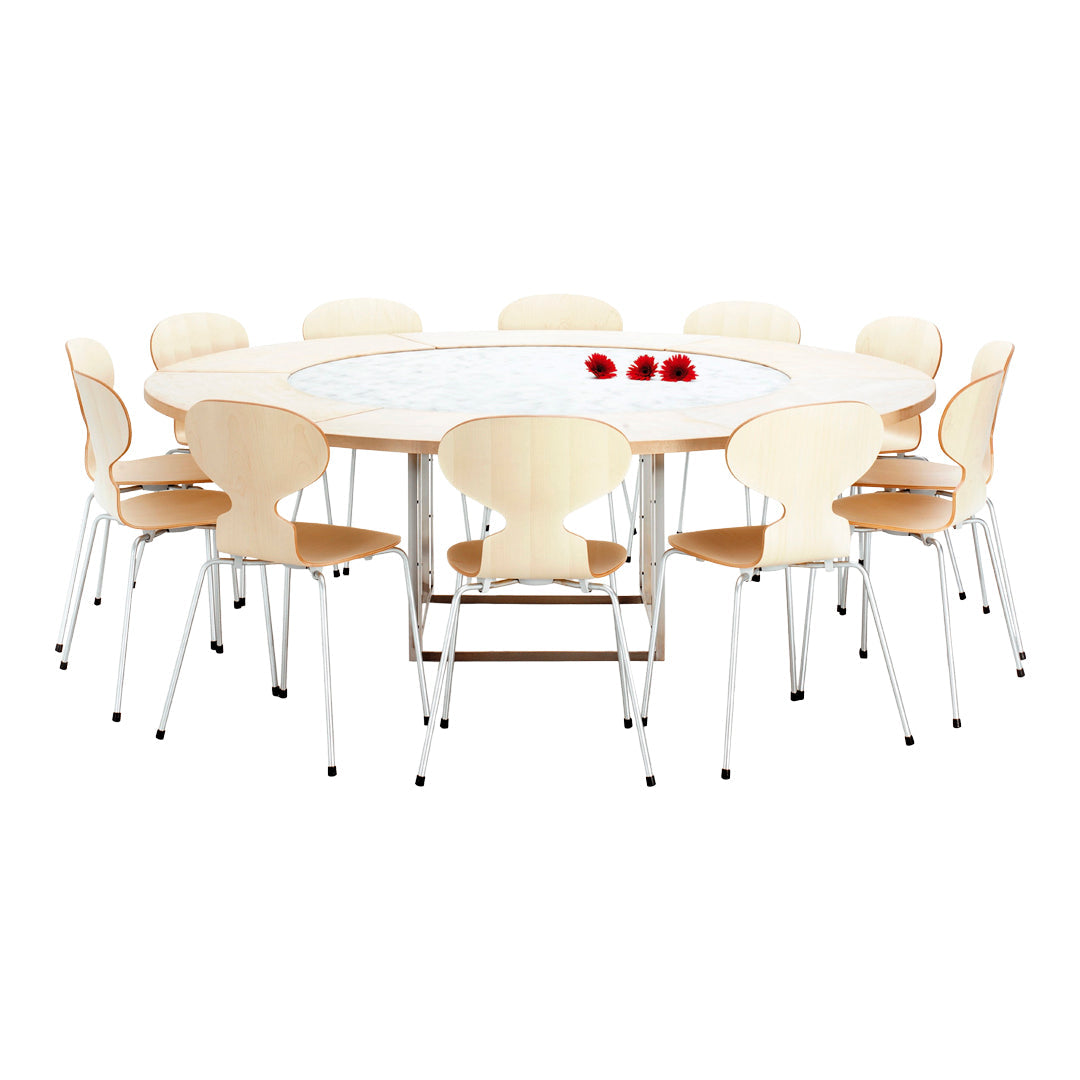 Round wooden table with light wood finish and white marble top, paired with beech wood chairs and red flower accents.