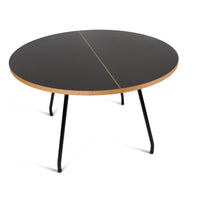 Round black table with a natural wood edge and minimalist design, featuring a sleek, modern aesthetic.