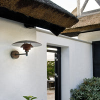 "Stylish wall lamp featuring a white shade with red and bronze accents against a modern exterior backdrop."