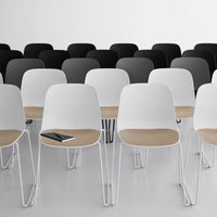Modern chairs in white and black, featuring sleek, minimalist designs with wooden accents in a stylish arrangement.