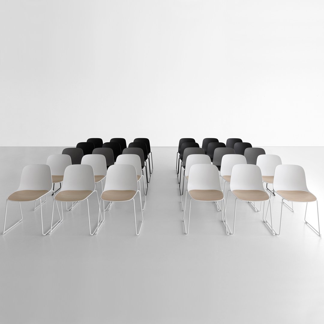 "Modern chairs in black, white, and wood tones, arranged in two rows on a minimalistic white background."