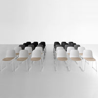 "Modern chairs in black, white, and wood tones, arranged in two rows on a minimalistic white background."