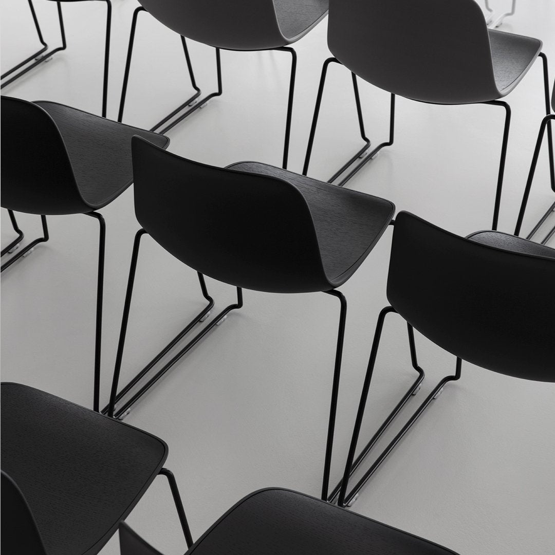 Black modern chairs with sleek lines and minimalist design on a light background.