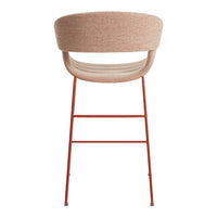 Light pink upholstered chair with a smooth texture and vibrant red metal legs. Modern design with a minimalistic pattern.