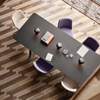 Elegant black table with purple and white chairs, set on a patterned wooden floor. Modern decor elements visible.