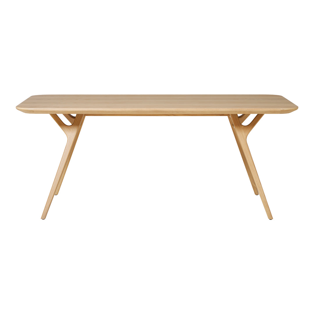Light natural wood dining table with a smooth finish and minimalist design, featuring sleek, angled legs.