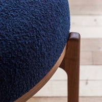 Navy blue textured upholstery with a smooth wooden frame, showcasing modern design and rich colors.