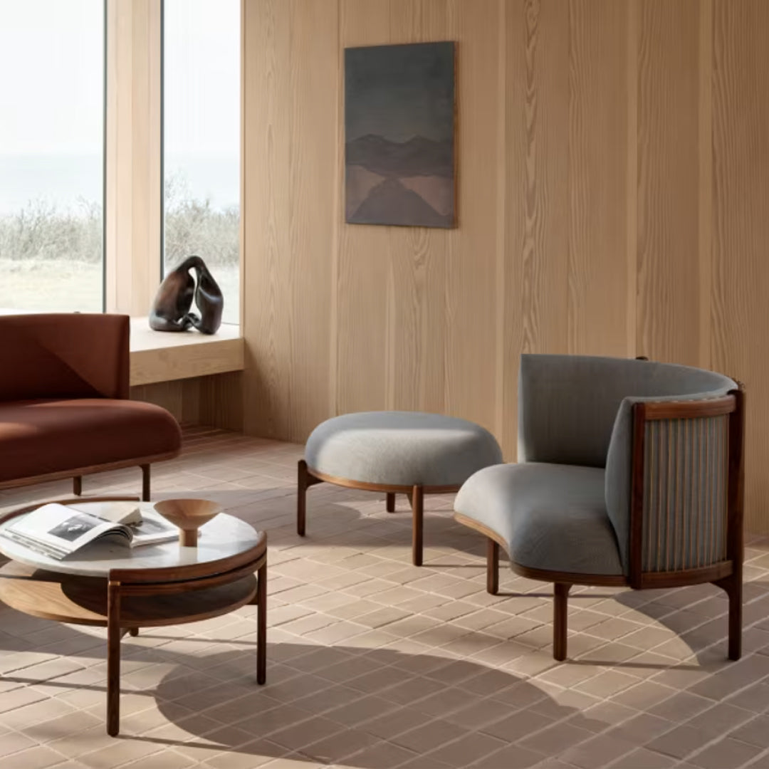 Modern gray and brown accent chairs with wooden frames, featuring soft upholstery and sleek lines in a minimalist setting.