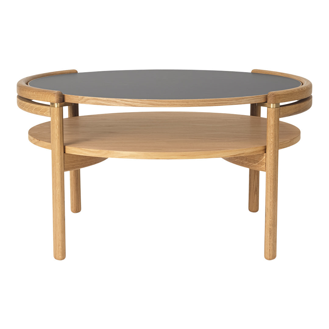 Elegant round coffee table with a black top and natural oak wood base, showcasing a minimalist design.