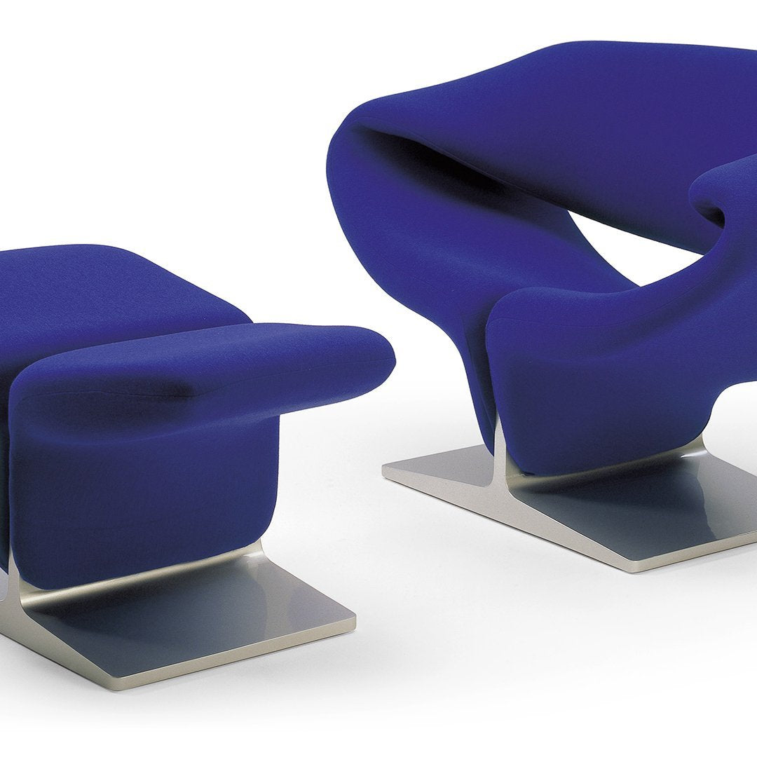 Vibrant blue modern chair and ottoman set with sleek metallic bases, featuring smooth, flowing curves.