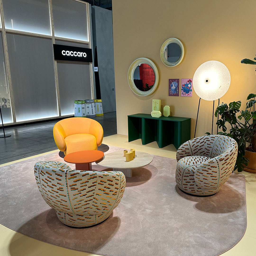 Vibrant yellow and orange chairs with textured patterns, paired with a soft beige rug and green accents. Modern decor setting.