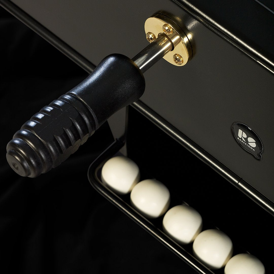 Black and gold handle with glossy black surface; white spherical accents below.