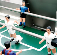 Colorful foosball figures in blue and white on a vibrant green playing field with white court markings.