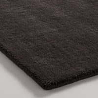 Black plush rug with a soft texture and subtle sheen, perfect for modern decor.