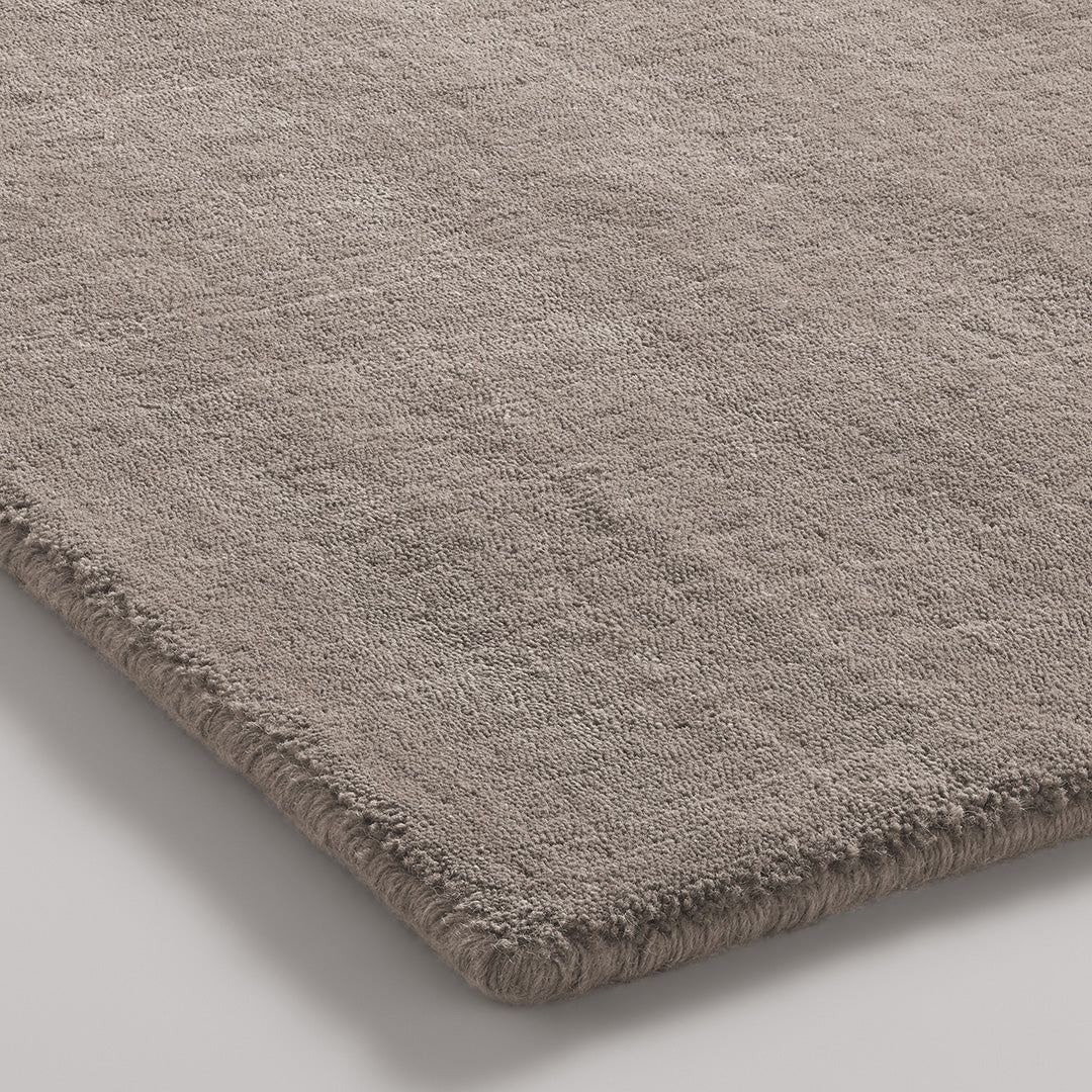 Soft beige rug with a subtle textured pattern and a plush finish, perfect for adding warmth to any space.