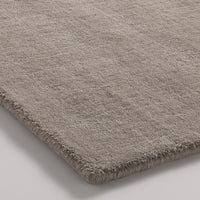 Soft beige rug with a subtle textured pattern and a plush finish, perfect for adding warmth to any space.