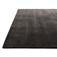 Soft black area rug with subtle texture, featuring a modern, minimalist design perfect for any decor.