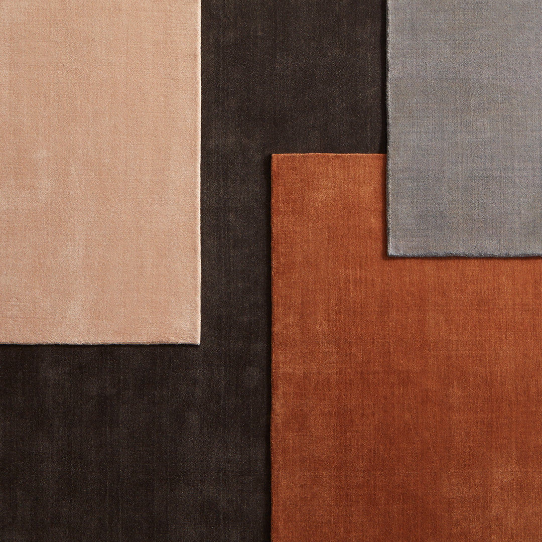 Square fabric swatches in blush, gray, rust, and dark brown, showcasing soft textures and subtle patterns.