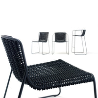 Black woven chairs with sleek metal frames, featuring minimalist design and a textured pattern for modern decor.