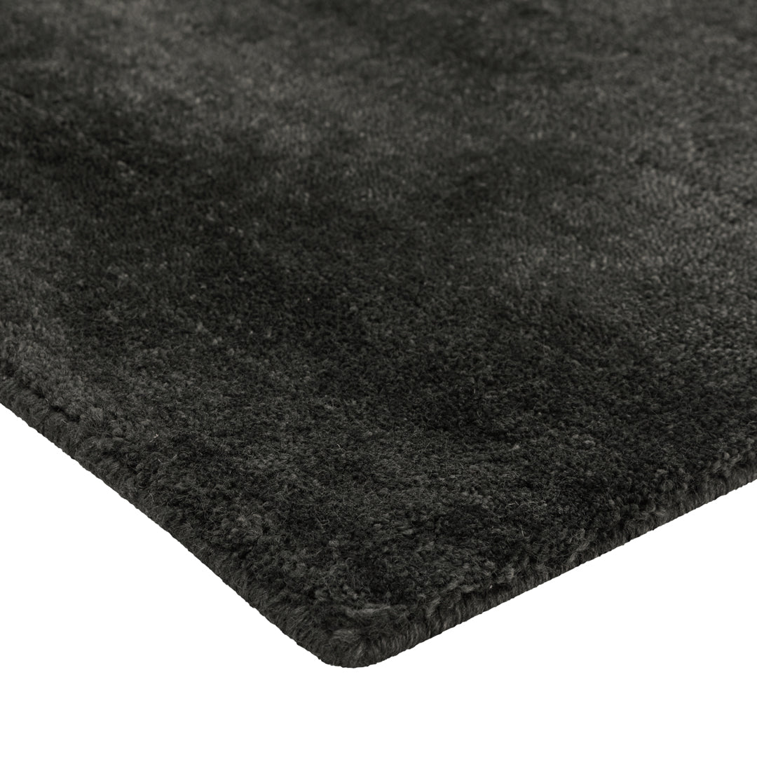 Soft black area rug with a textured, shaggy finish, perfect for modern decor.