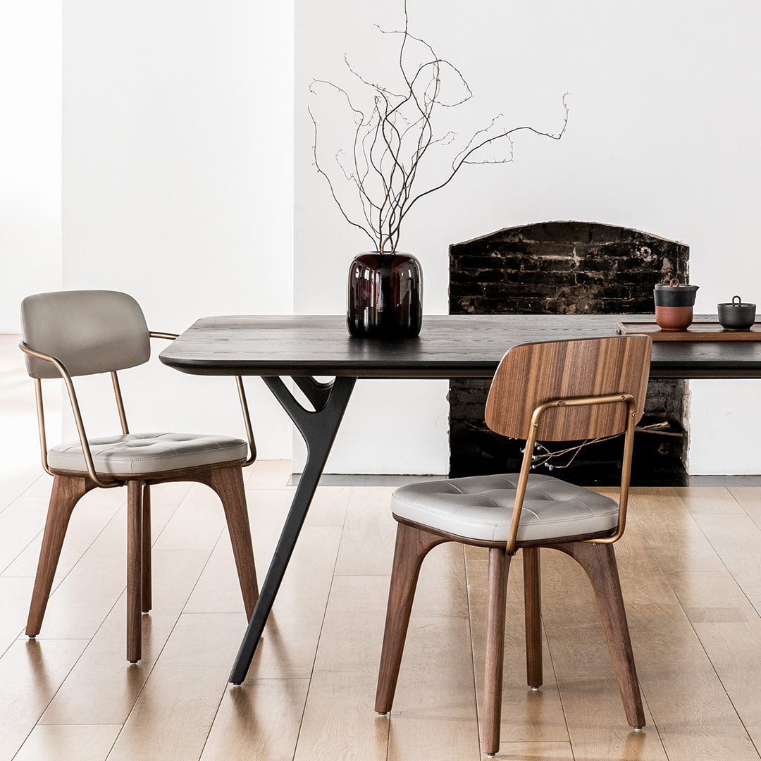Stylish black dining table with gray and wooden chairs, featuring a modern minimalist design and neutral color palette.