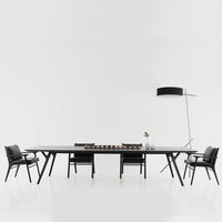 Sleek black dining table with modern geometric patterns, paired with stylish black chairs.