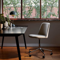 Cream and gray office chair with sleek fabric, set against a warm wooden floor and natural greenery backdrop.