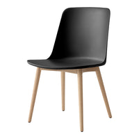 Black minimalist chair with smooth curves and natural wood legs, perfect for modern decor.