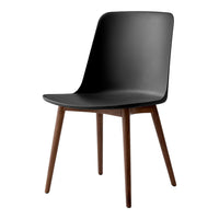 "Modern black chair with smooth finish and wooden legs, featuring minimalist design and sleek silhouette."