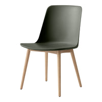 Matte dark green chair with smooth curves and light wood legs, showcasing a minimalist design.