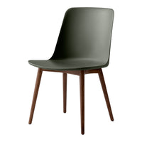 Green plastic chair with sleek design and wood legs, perfect for modern decor and minimalist aesthetics.