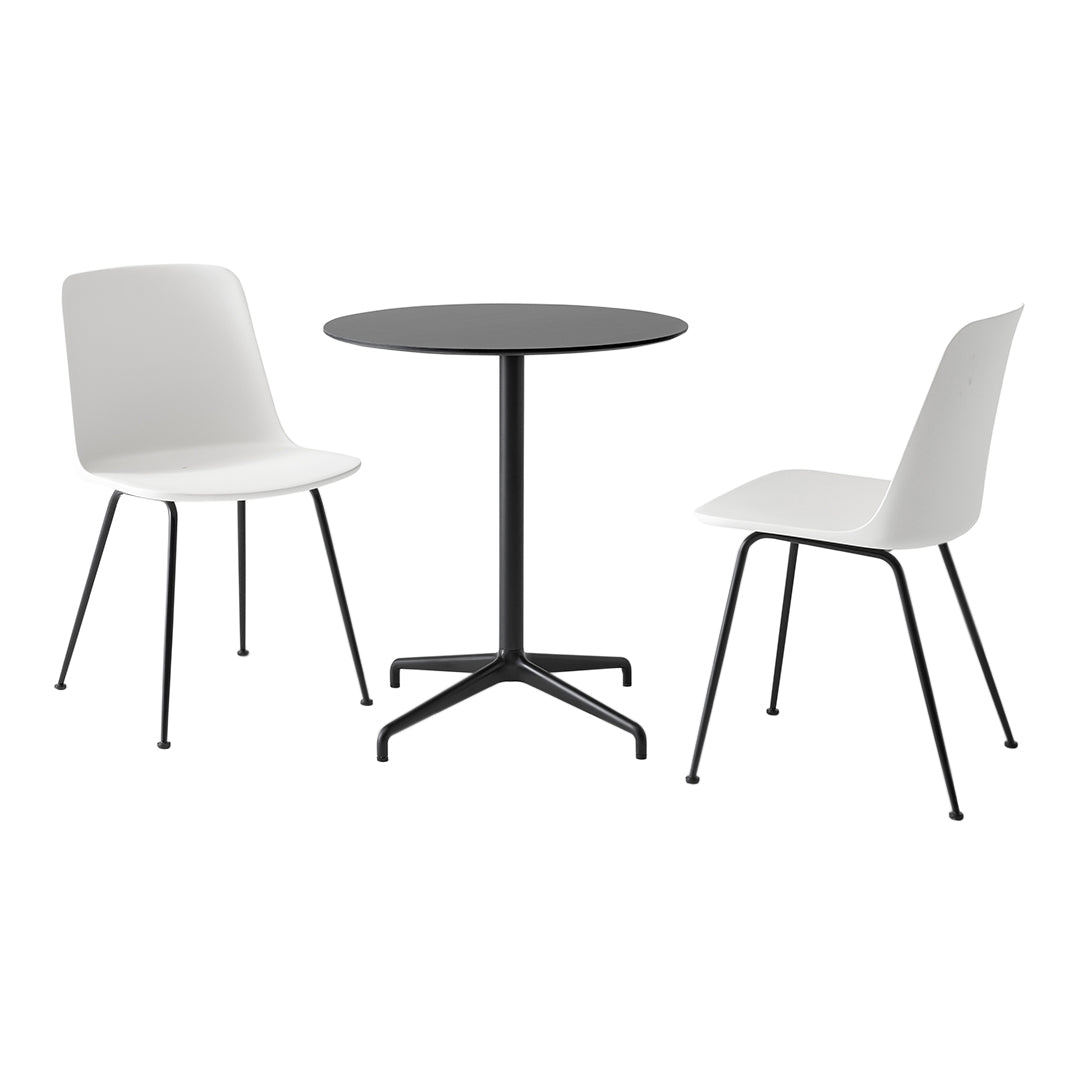 Modern white chairs and a round black table, creating a sleek, minimalist dining set with contrasting colors.