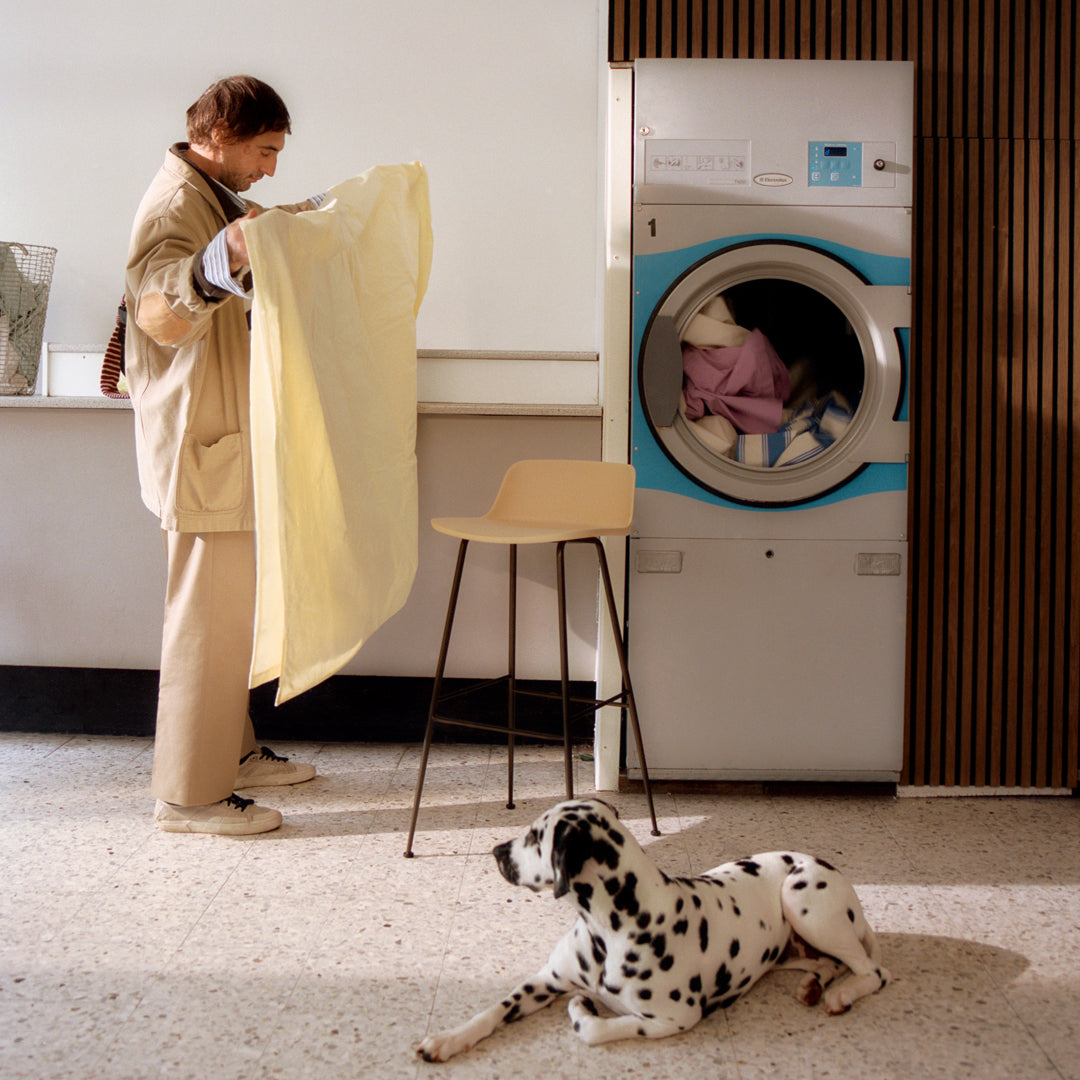 "Soft yellow blanket with subtle texture, contrasting against a blue washing machine and a patterned Dalmatian."