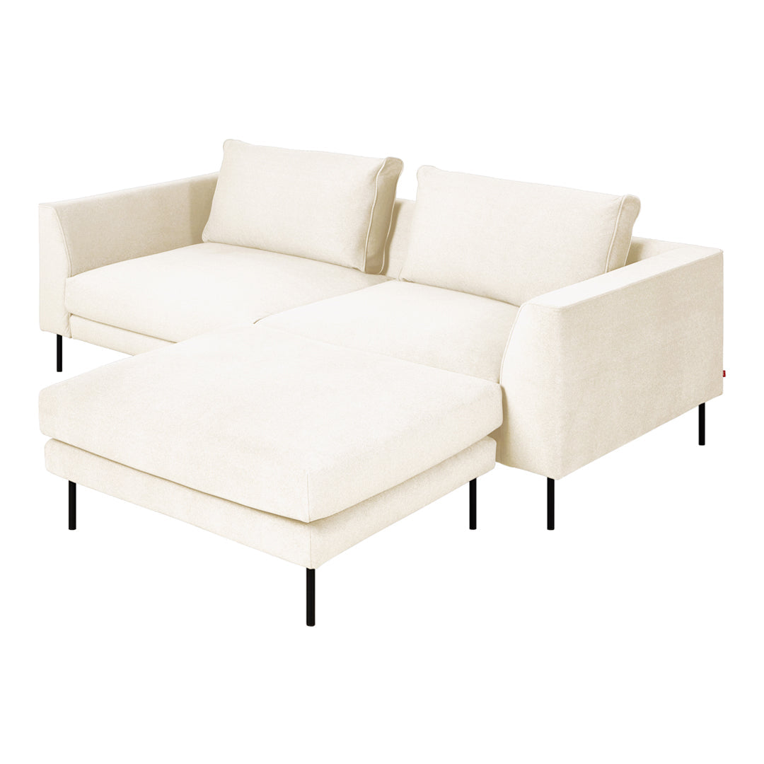 Cream-colored sectional sofa with a minimalist design and soft, solid fabric upholstery.