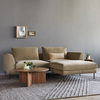 Beige sectional sofa with a textured fabric, complemented by a wooden coffee table and soft gray rug.