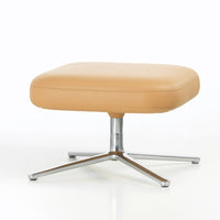Tan square ottoman with smooth surface, featuring a sleek chrome base, perfect for modern decor.