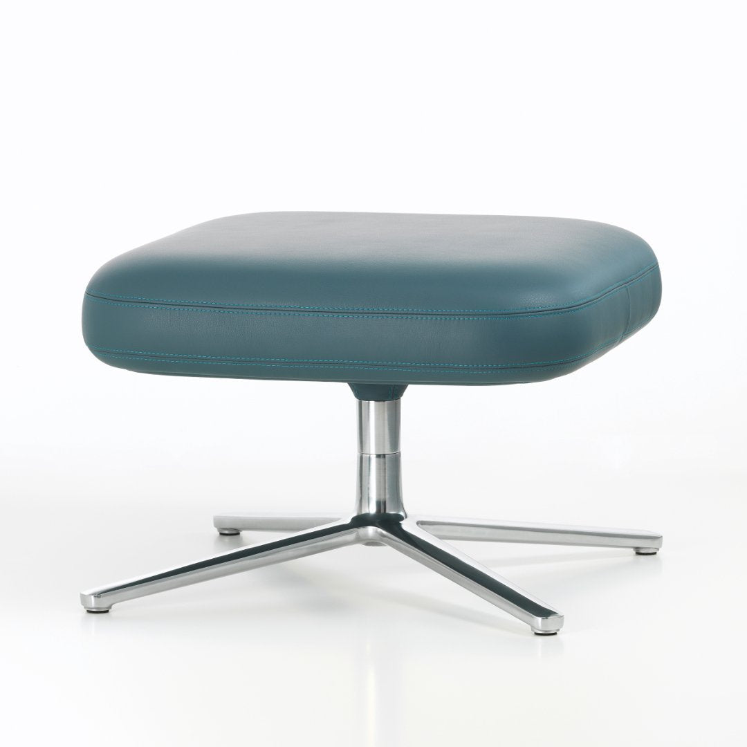 Teal leather cushion ottoman with a sleek chrome base, showcasing a minimalist design and smooth finish.