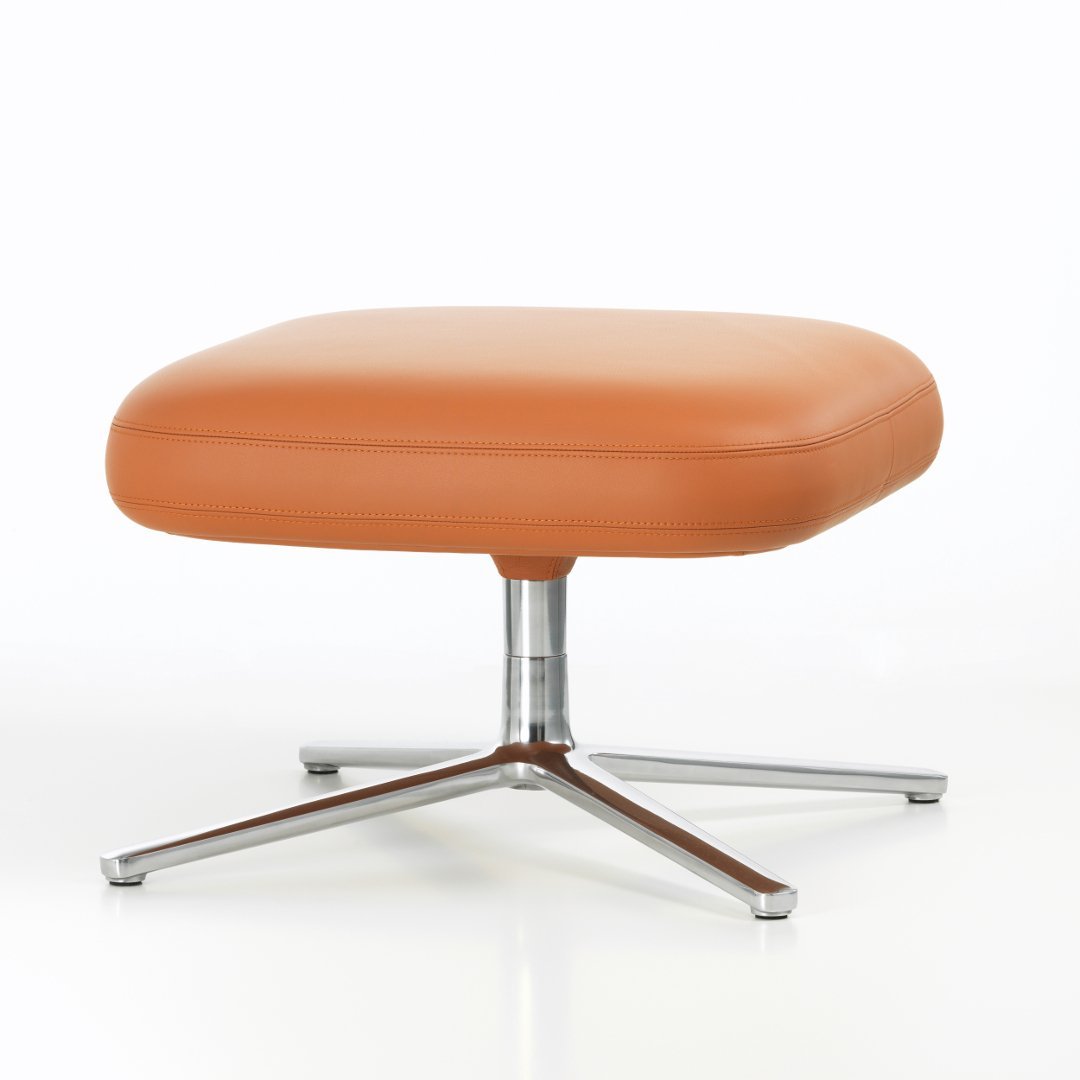 Stylish square orange leather ottoman with a sleek silver base, perfect for modern decor.