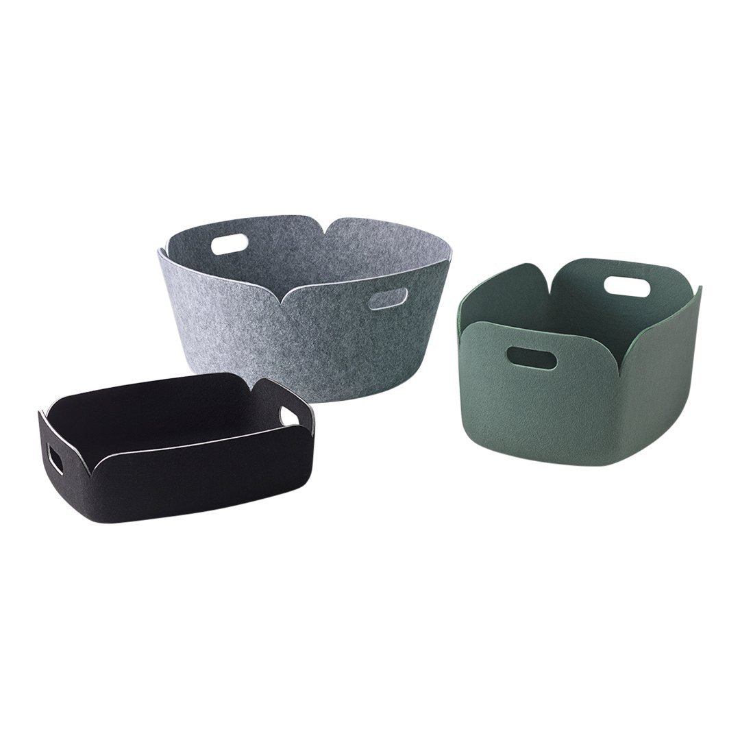 Three storage baskets in grey, black, and green felt with unique curved edges and handle openings.