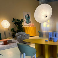 Modern interior with yellow and green tones, circular light fixtures, and textured furnishings. 