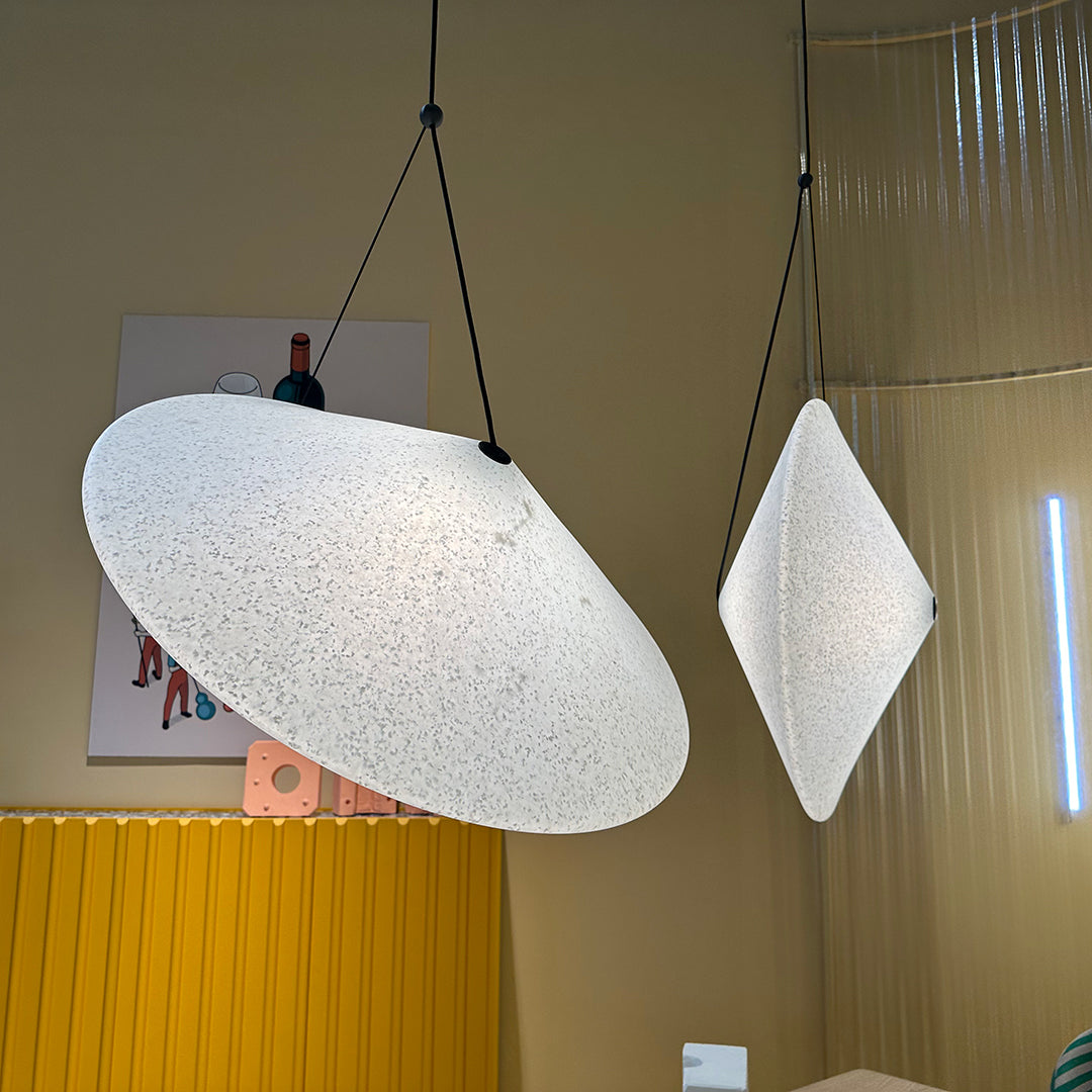 White textured pendant lights with a modern design, featuring smooth curves and geometric shapes in a minimalistic setting.