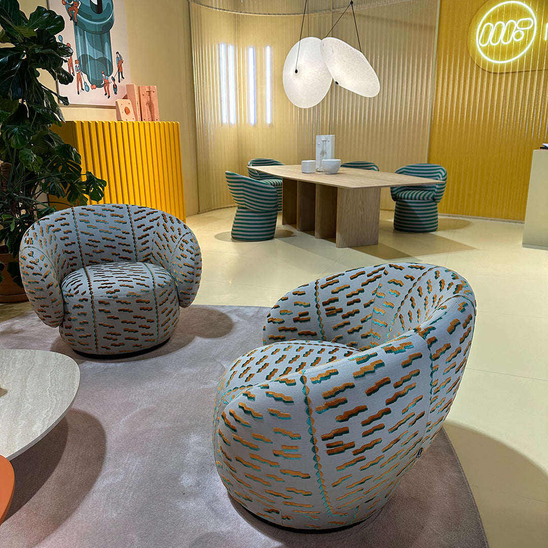"Stylish armchairs with a light blue and orange pattern set against a soft pastel backdrop."