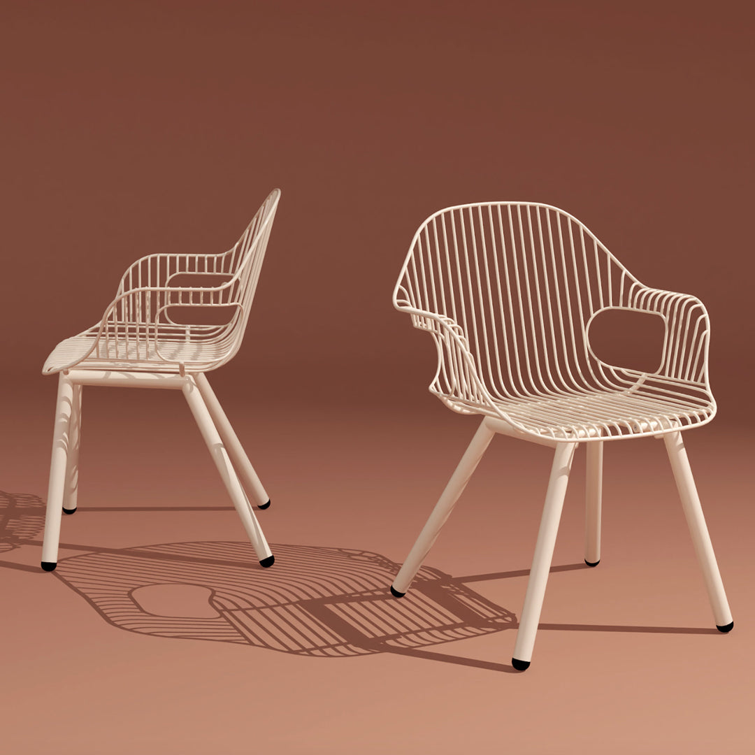 "White wire-framed chairs with a sleek design, set against a warm, earthy background."