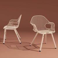 "White wire-framed chairs with a sleek design, set against a warm, earthy background."